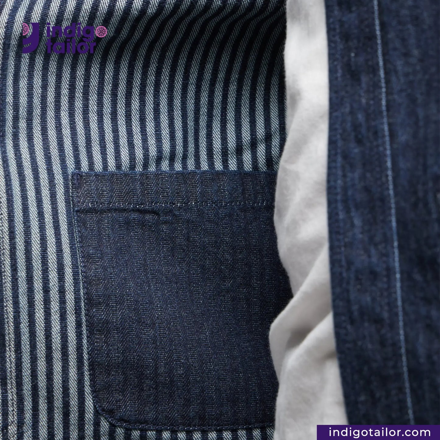 Close-up of a BASEBALL NORAGI (DARK INDIGO) inside pocket with striped fabric background, featuring Indigo Tailor logo.