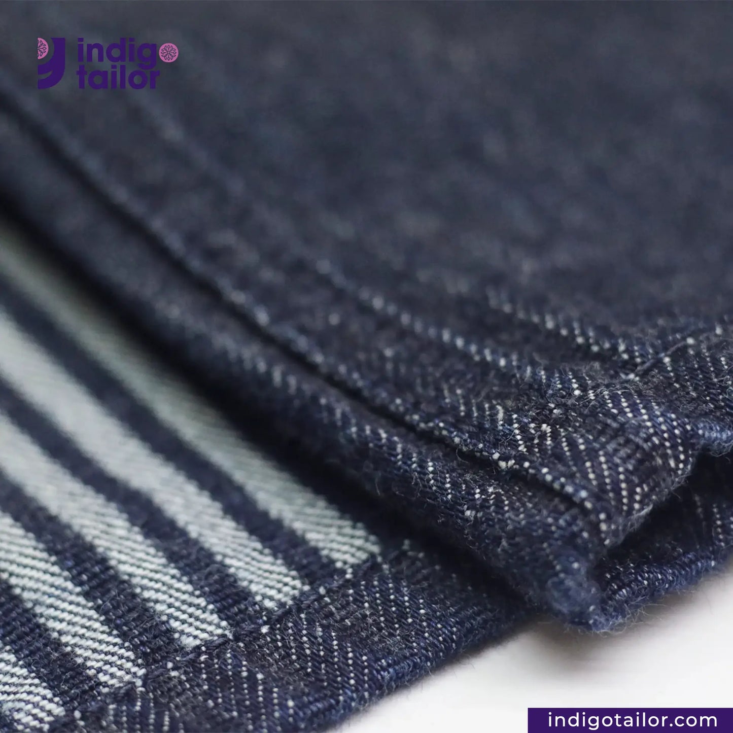 Close-up of BASEBALL NORAGI (DARK INDIGO) denim fabric with 'Indigotailor' branding.