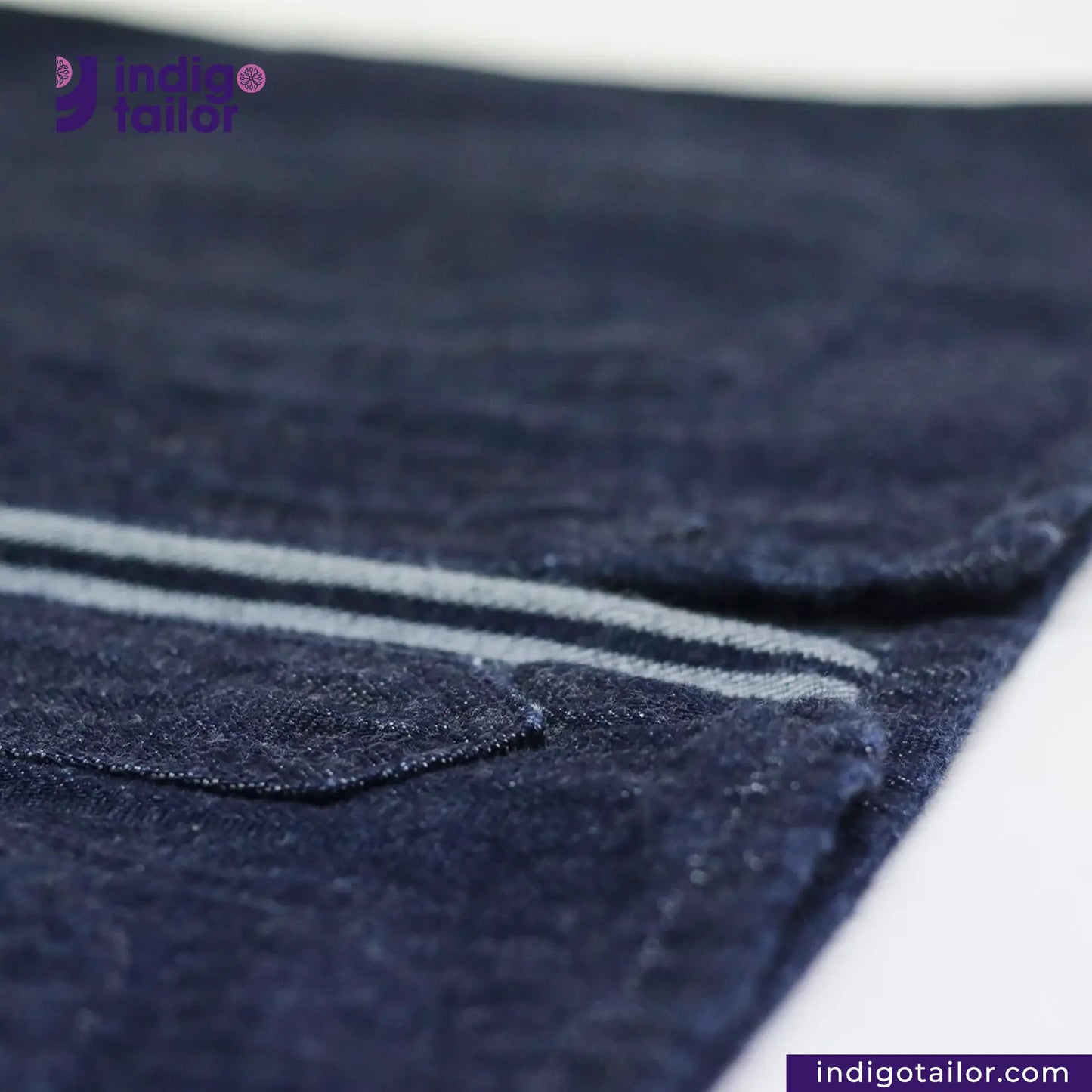 Close-up of BASEBALL NORAGI (DARK INDIGO) fabric with a visible brand logo in the corner.
