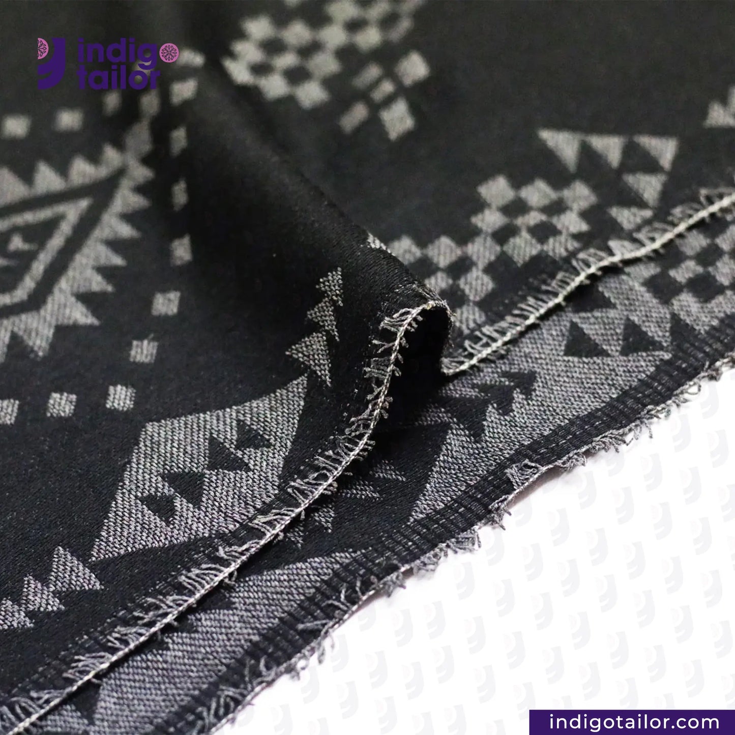 Close-up of BLACK NATIVE AMERICAN JACQUARD fabric with geometric pattern, branded 'Indigo Tailor'.
