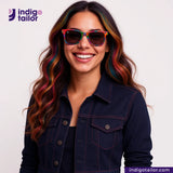 Woman wearing colorful sunglasses and a BLUE ROYAL INDIGO x BLACK SELVEDGE DENIM jacket with Indigotailor logo.
