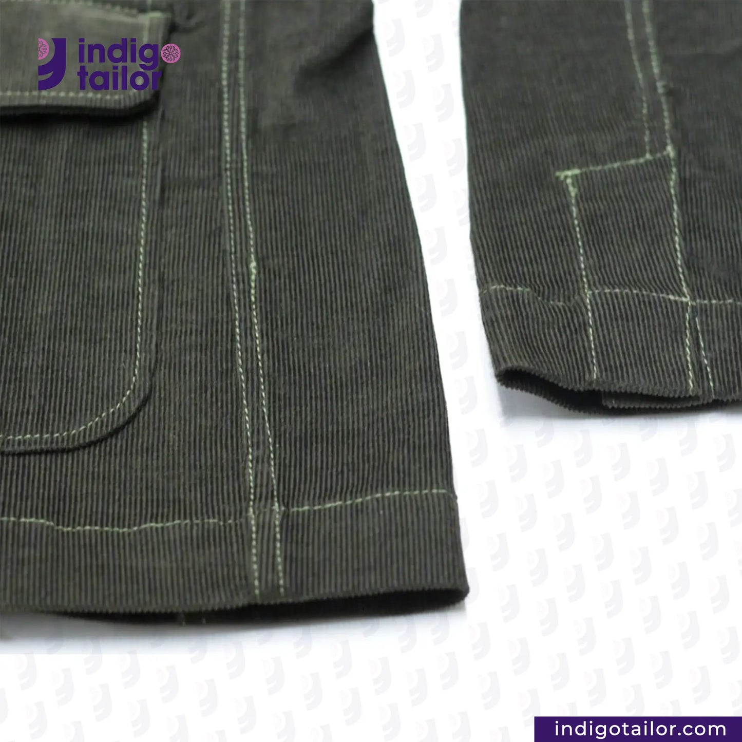 Close-up of CORDUROY CHORE BLAZER (OLIVE) fabric with stitching details on a white background, featuring the Indigotailor logo.