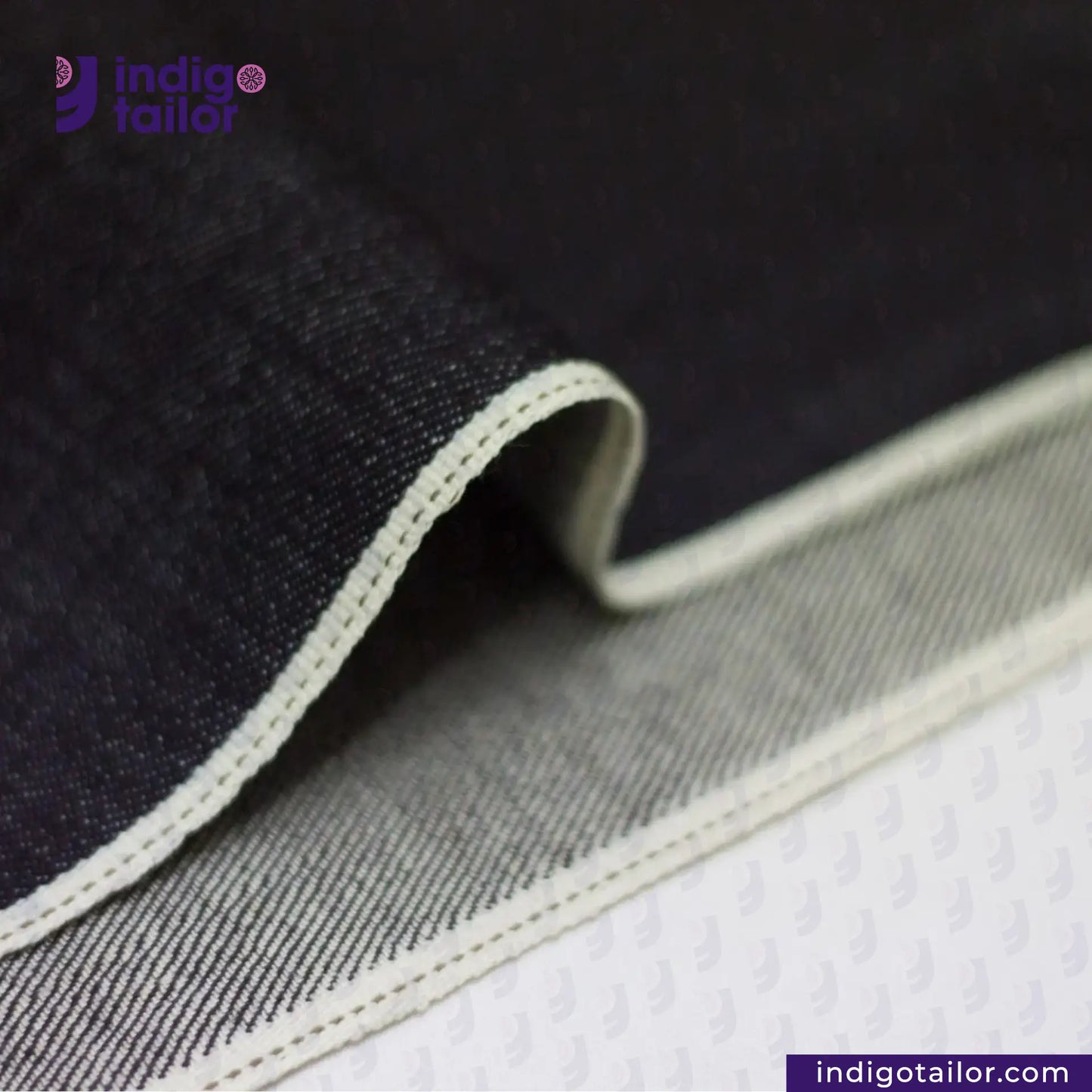 Close-up of DEEP INDIGO STRETCH SELVEDGE DENIM fabric with a visible brand logo and website.