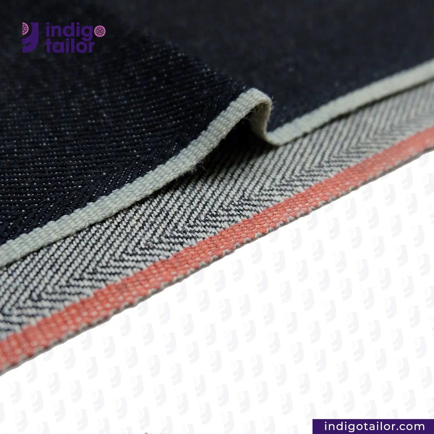 Close-up of DEEP INDIGO TWO COLORED EDGE SELVEDGE DENIM fabric with a herringbone pattern and 'Indigotailor' branding.
