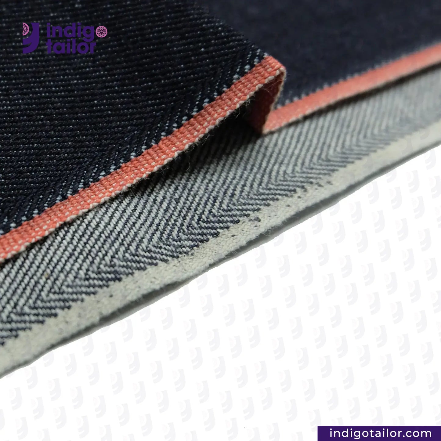 Close-up of DEEP INDIGO TWO COLORED EDGE SELVEDGE DENIM fabric with a visible brand logo on a white background