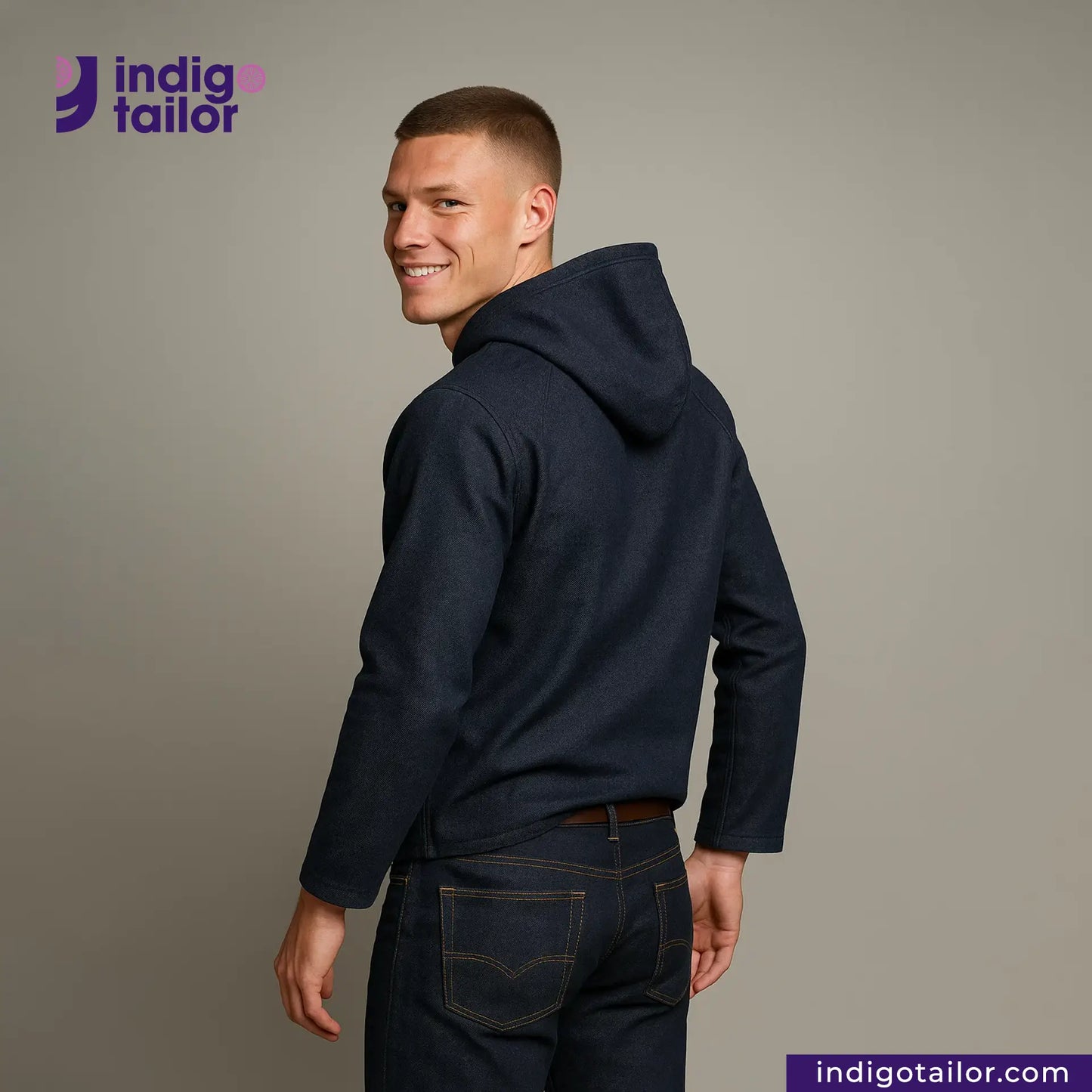 Man wearing a DENIM HOODIE and jeans with 'Indigo Tailor' logo and website on a gray background