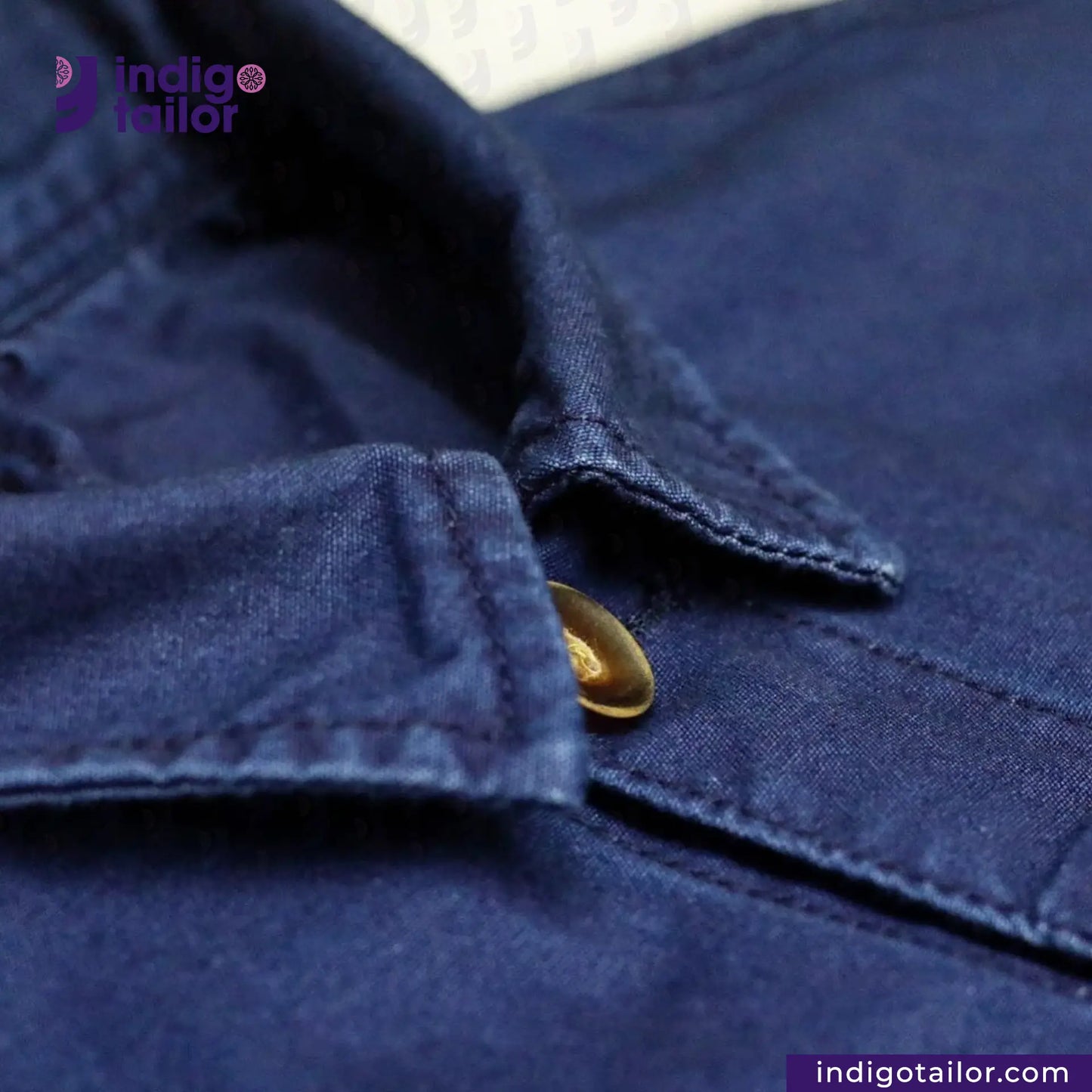 Close-up of a EASY JACKET INDIGO CANVAS with a button, featuring the 'indigotailor' brand.
