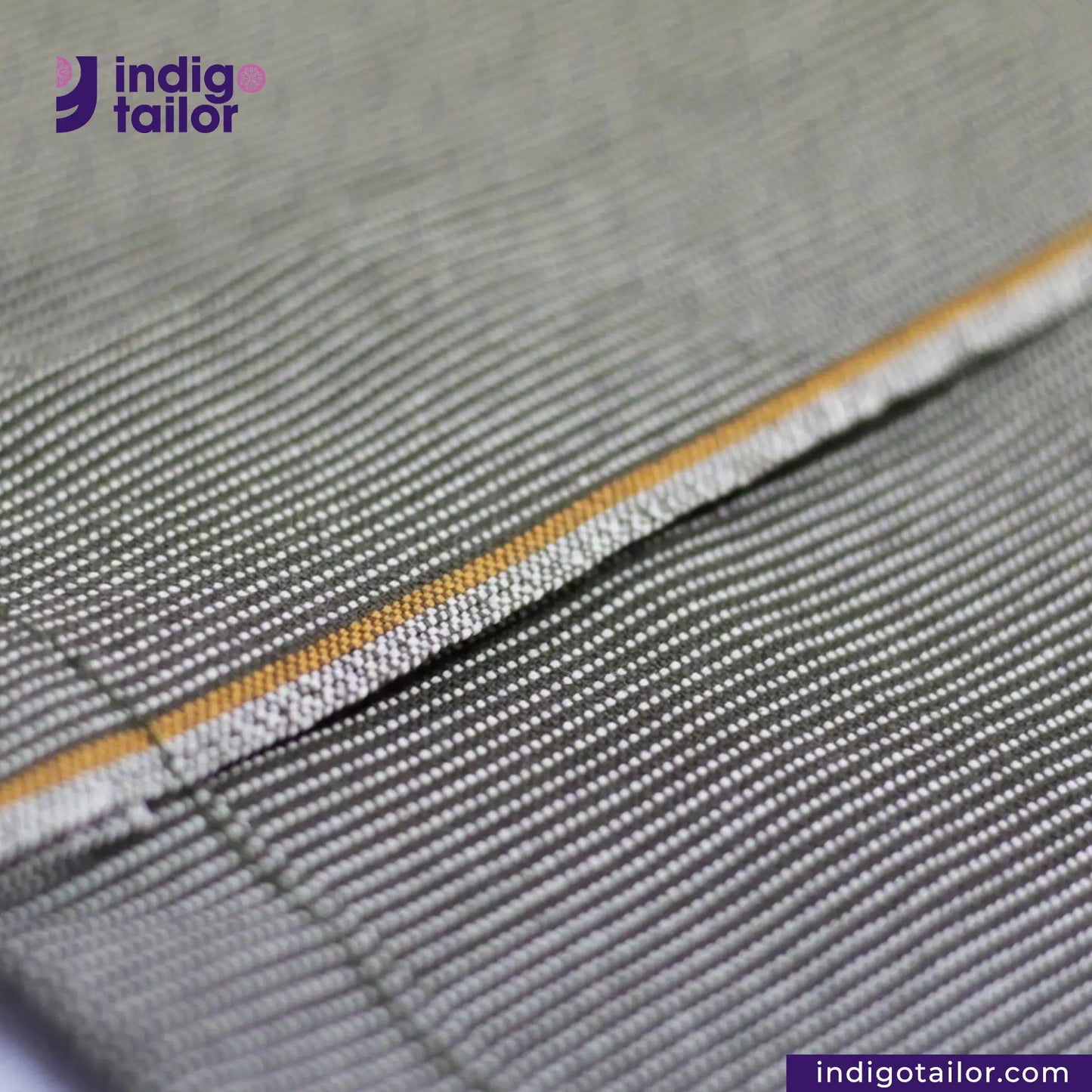 Close-up of EASY JACKET OLIVE WABASH ONE WASH with yellow stitching detail, featuring 'indigo tailor' logo.
