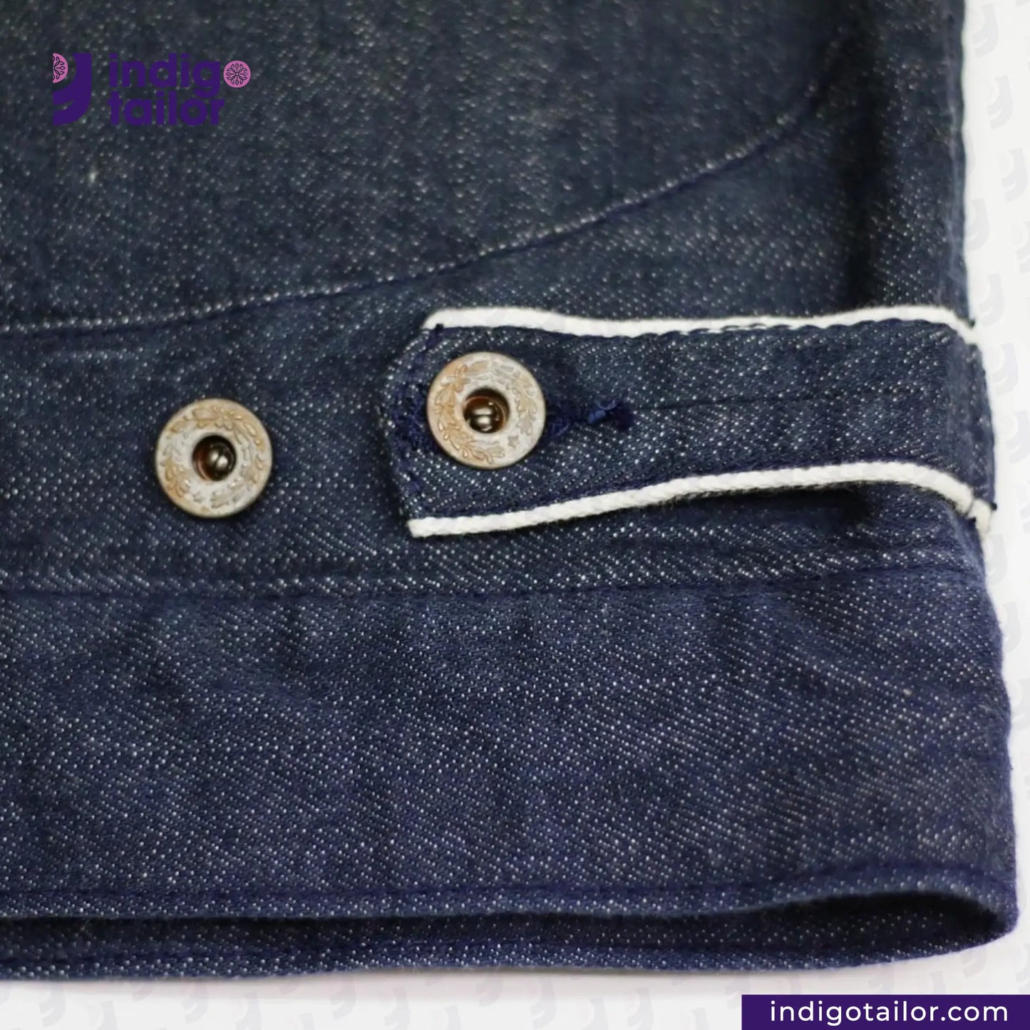 Close-up of a FLIGHT JACKET with buttons and white piping on a white background, featuring the Indigo Tailor logo.