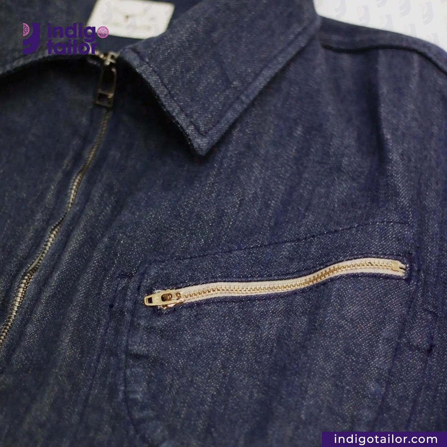 Close-up of a FLIGHT JACKET with a zipper pocket, brand 'Indigo Tailor' visible.