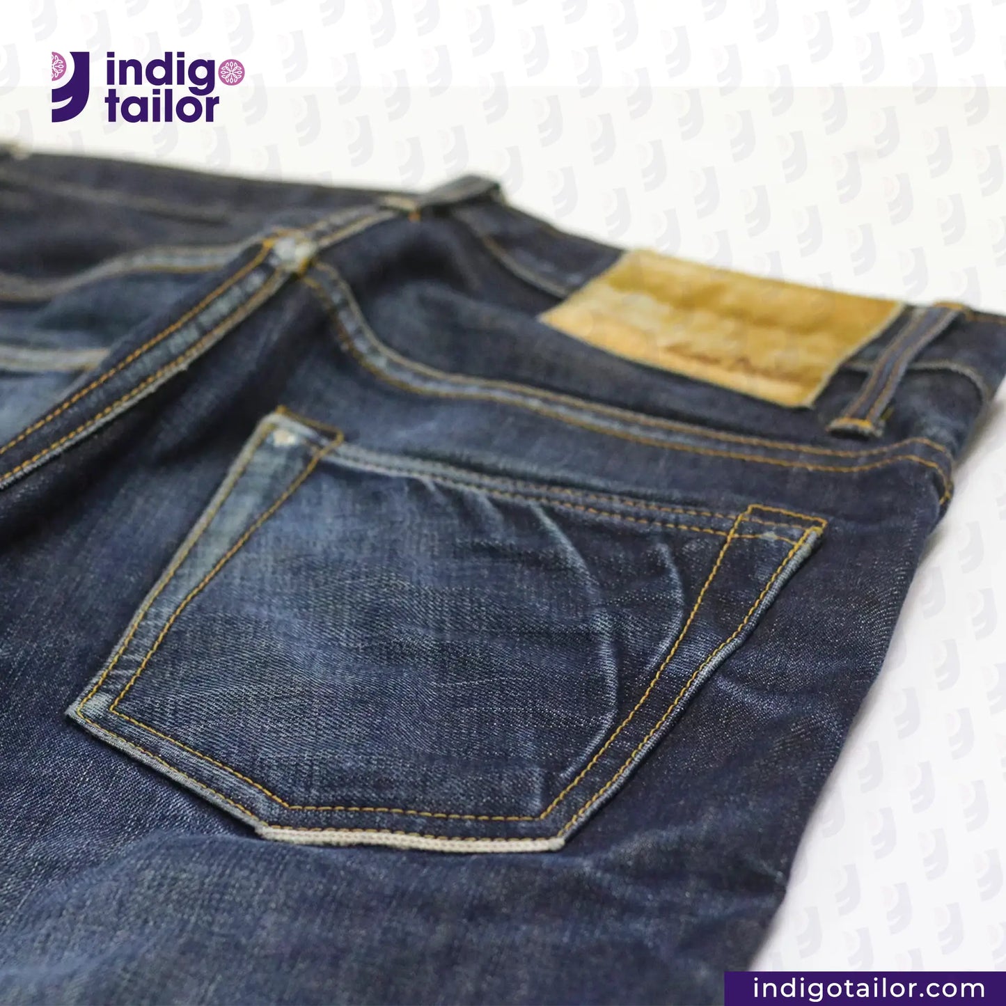 Close-up of blue jeans with a visible brand logo on a textured background