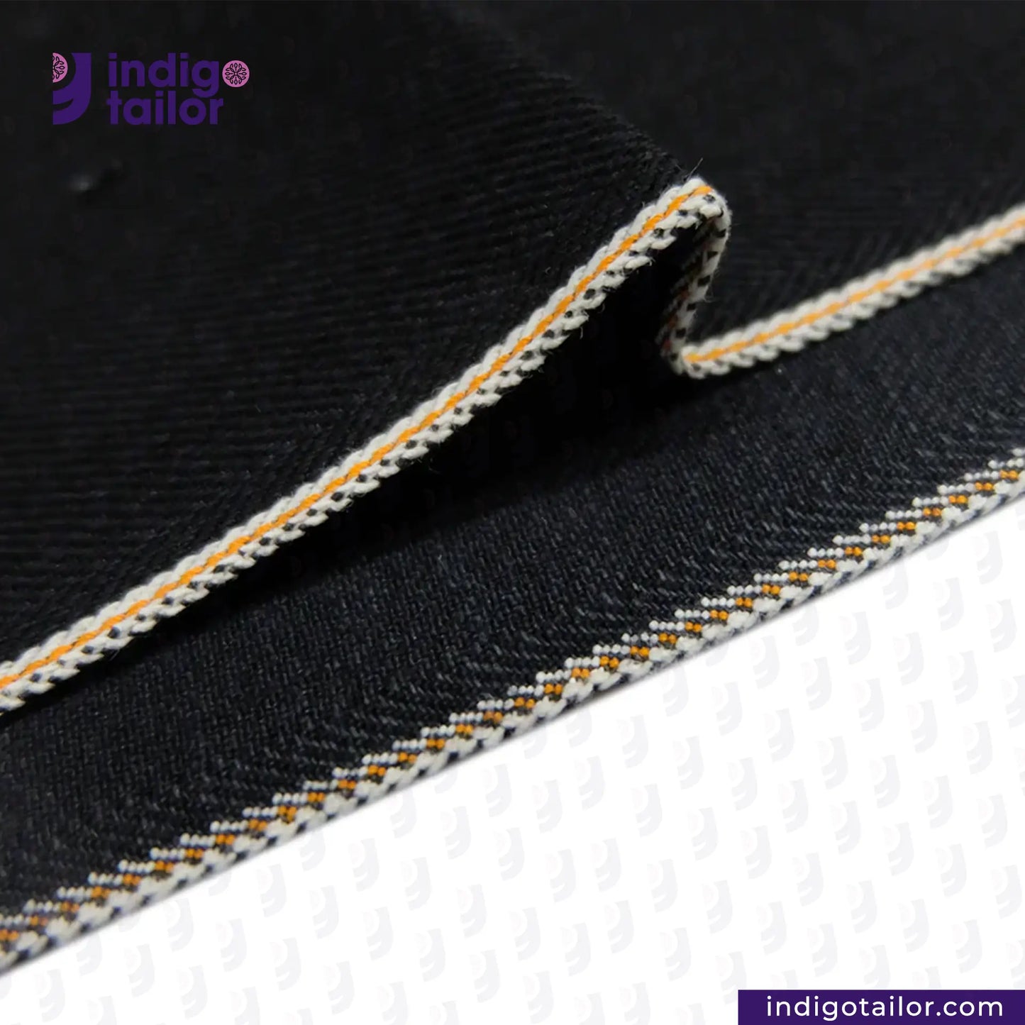 Close-up of HEAVY DOUBLE BLACK ORANGE SELVEDGE ID fabric with white and orange stitching, featuring the Indigotailor logo.