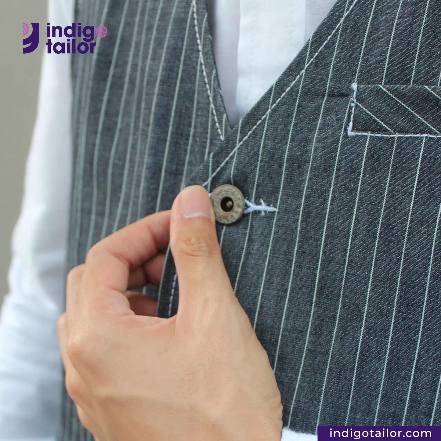 Person buttoning a INDIGO VINTAGE STRIPE WORK VEST with 'indigotailor' branding.