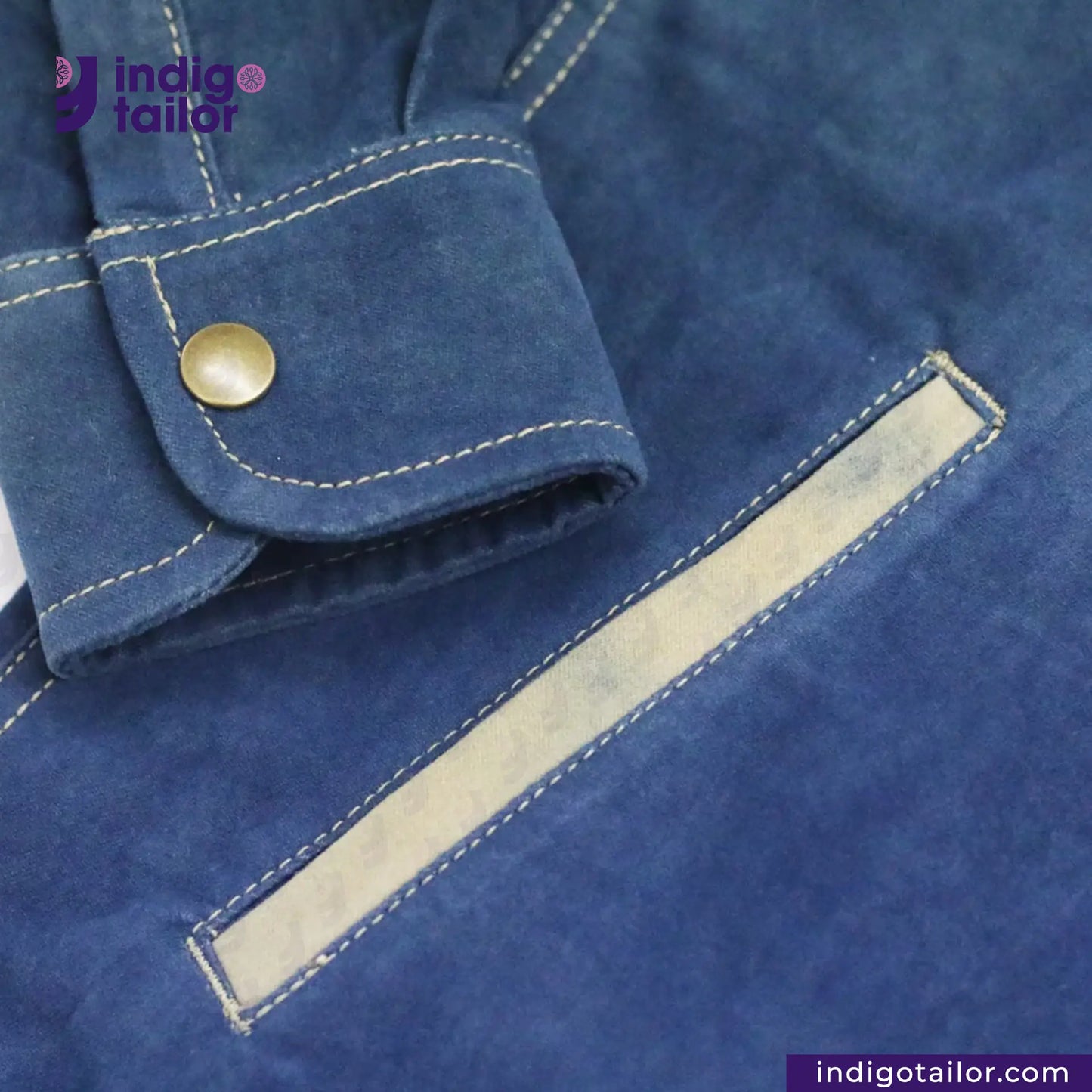 Close-up of a NATURAL INDIGO SUEDE SHACKET with a button and pocket, featuring the 'Indigotailor' brand.