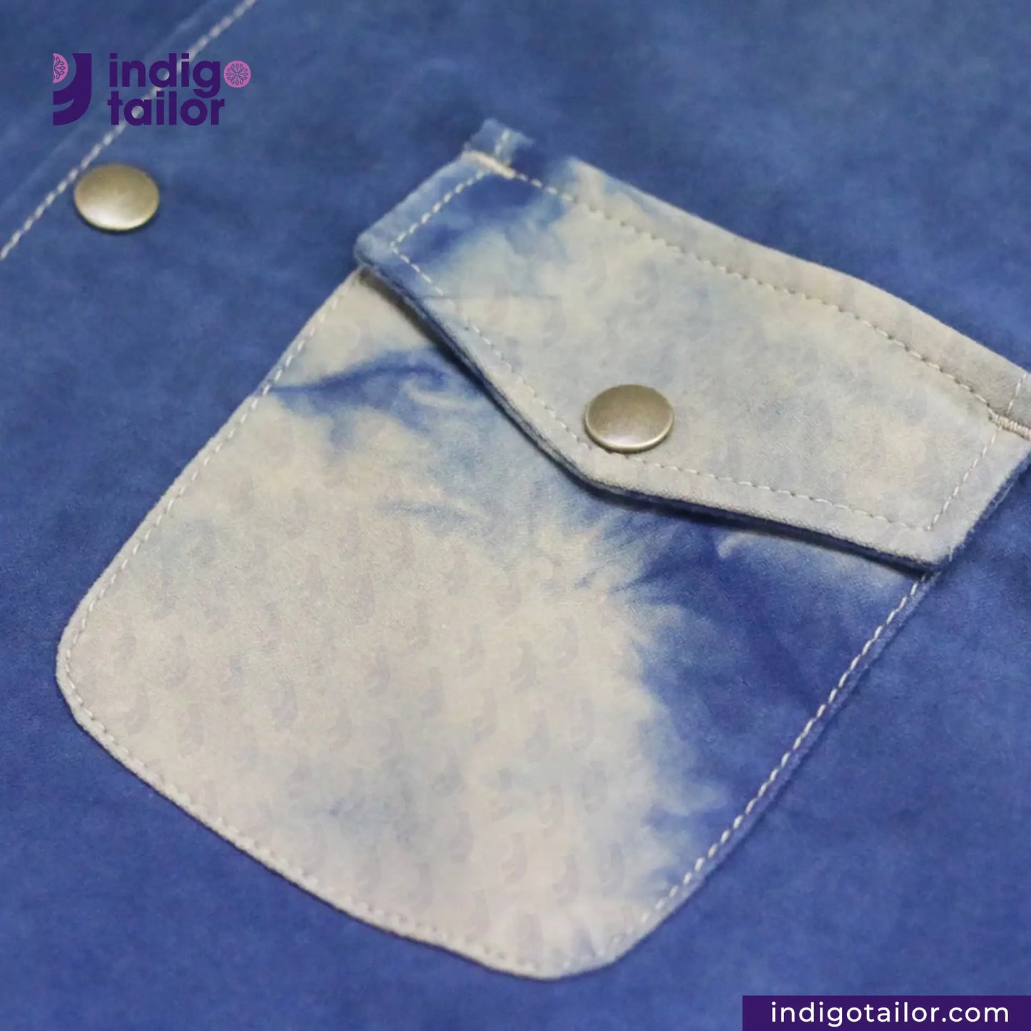 Close-up of a NATURAL INDIGO SUEDE SHACKET pocket with a button, featuring the 'indigotailor' brand.