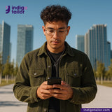 Man using a phone with a cityscape background and Indigo Tailor logo. Wearing OLIVE CORDUROY Jacket.