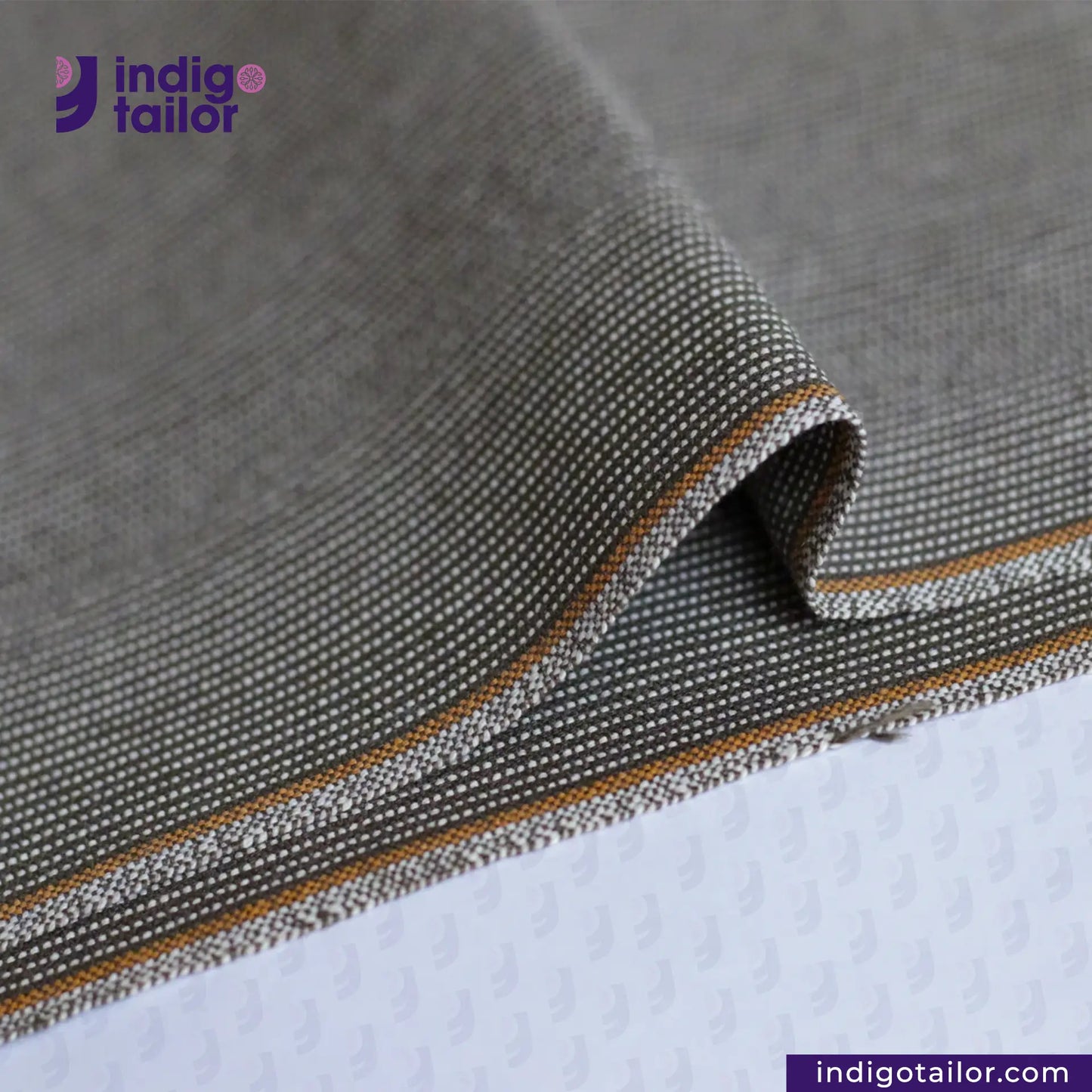 OLIVE WABASH SELVEDGE DENIM fabric with orange stitching on a textured surface, featuring the Indigotailor logo.
