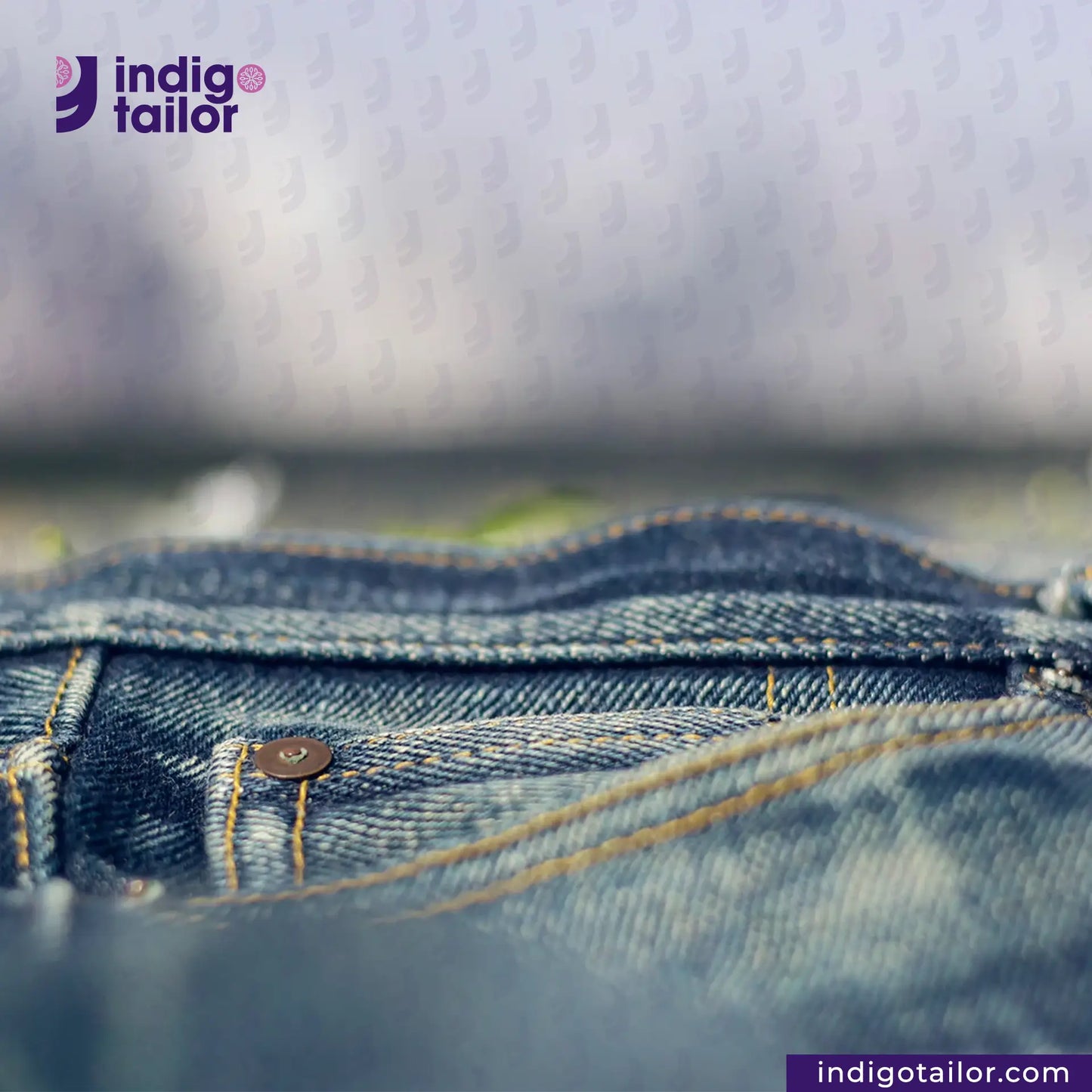 Close-up of blue denim fabric with 'indigotailor' logo in the corner.