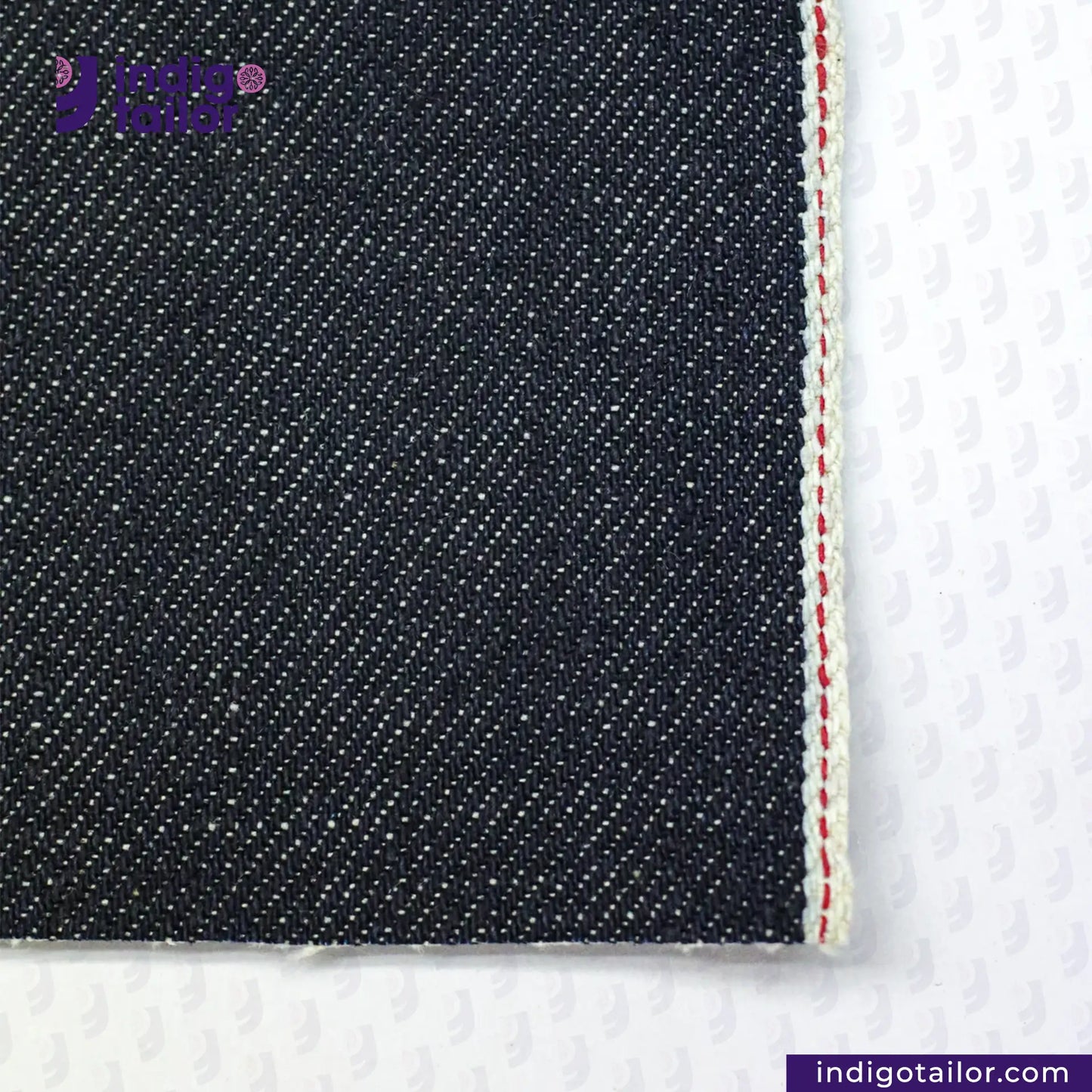 Close-up of ORGANIC NATURAL COTTON SELVEDGE DENIM fabric with a visible brand logo on a white background