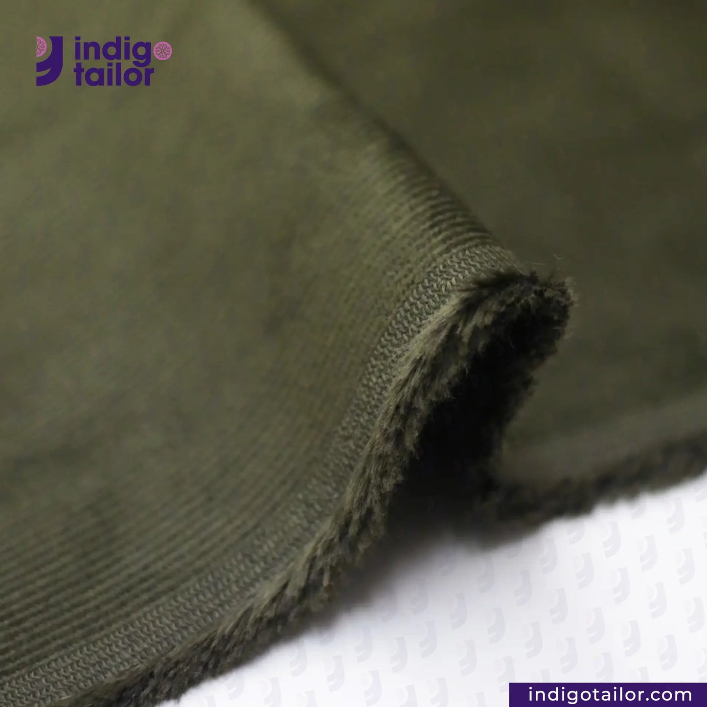 Close-up of Olive Green Corduroy fabric with 'Indigotailor' logo and website on a white background