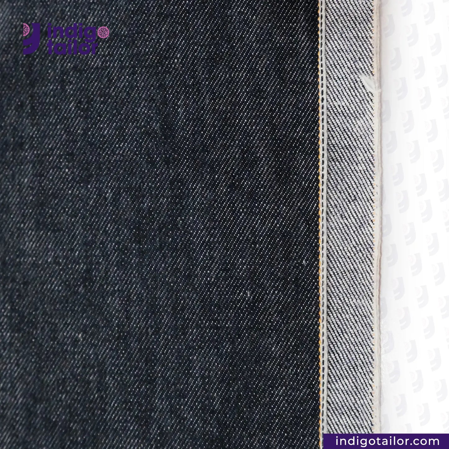 Close-up of ROUGH-SPUN DENIM FUZZY HANDFEEL fabric with a visible brand logo on a white background