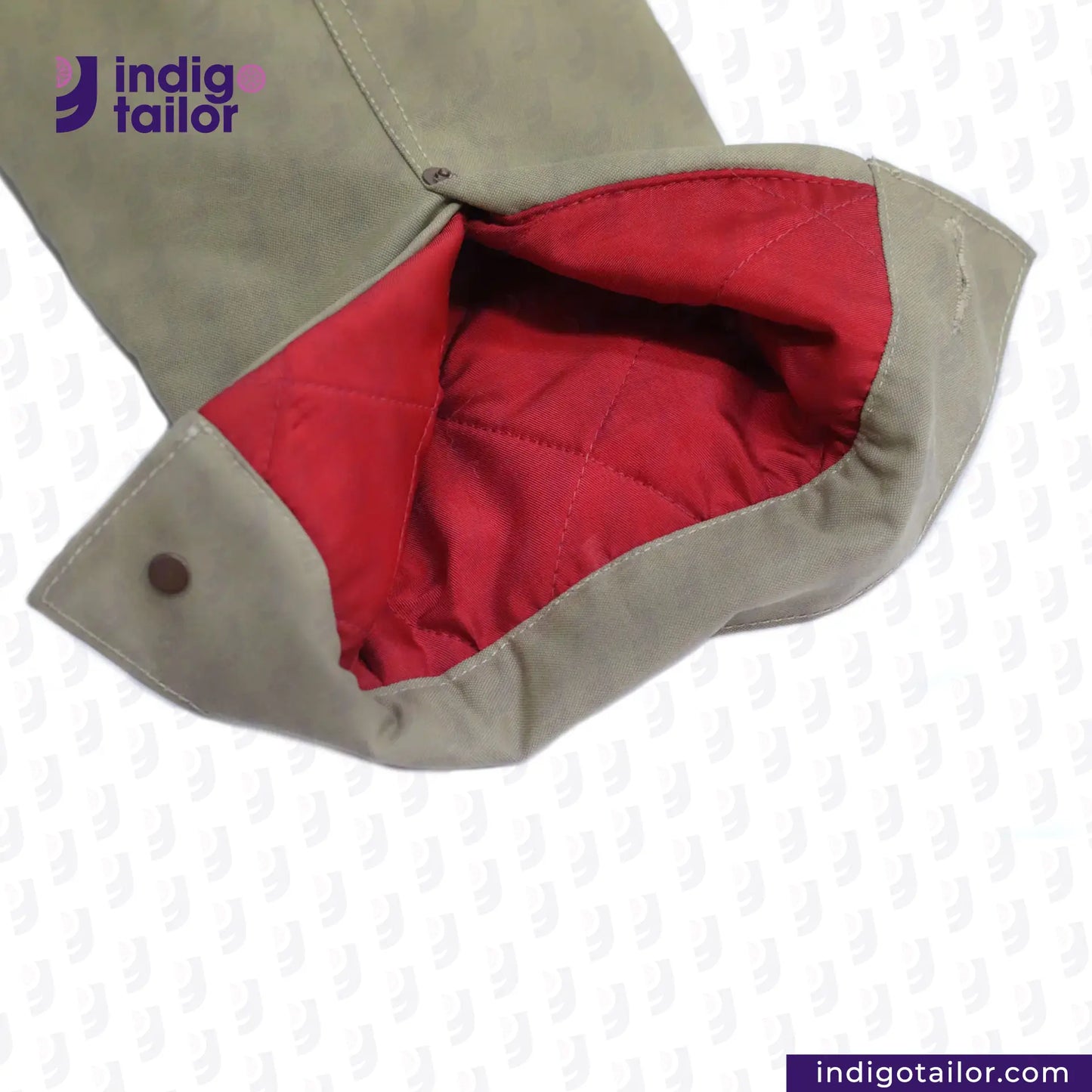 Close-up of a SHERPA LINED WAXED CANVAS TRUCKER JACKET with red lining and 'indigotailor' branding.