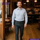 Man walking through a cafe wearing a light blue shirt and SMOKE GREY DENIM pants, with Indigo Tailor logo in the corner.