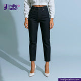Person wearing SNOWY SELVEDGE DENIM jeans and white shoes on a light blue background with 'indigotailor' branding.
