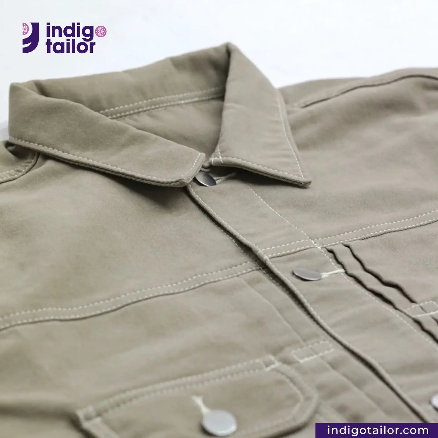 Close-up of a SUEDE JACKET with collar and buttons, featuring the Indigotailor logo.