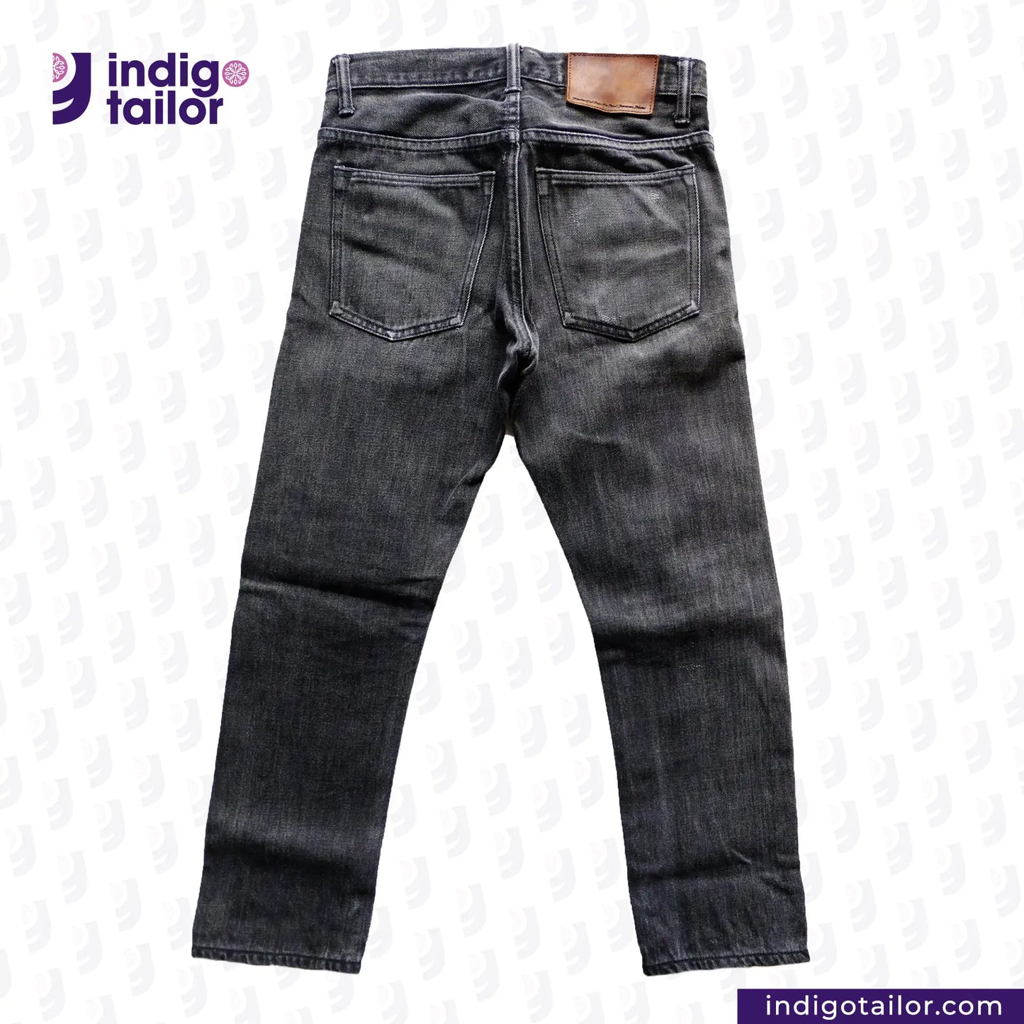 Back view of a pair of SUPER BLACK DENIM jeans with 'Indigo Tailor' branding on a light background.