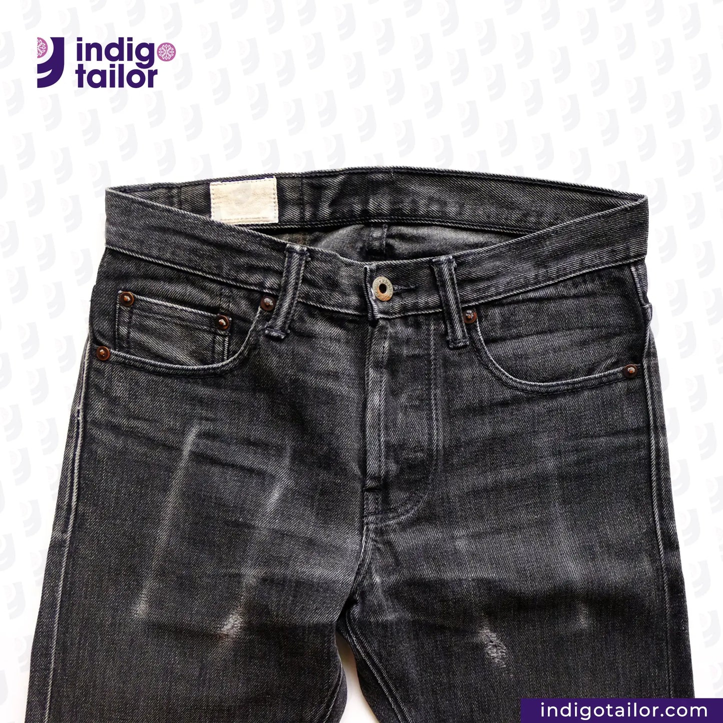 SUPER BLACK DENIM jeans with visible wear on a white background, featuring the Indigotailor logo.