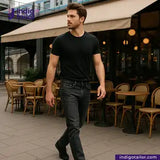 Man walking outdoors with tables and chairs in the background wearing SUPER BLACK DENIM jeans.