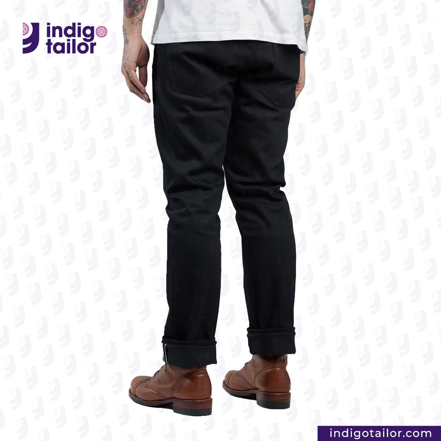 Person wearing SUPER BLACK DENIM pants and brown boots with 'Indigo Tailor' logo.