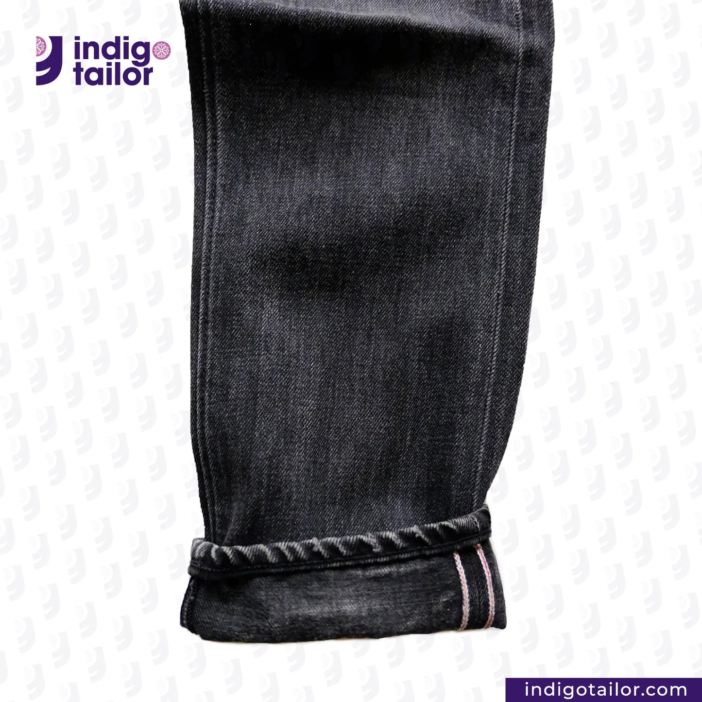 Close-up of SUPER BLACK DENIM jeans with a visible brand logo on a white background