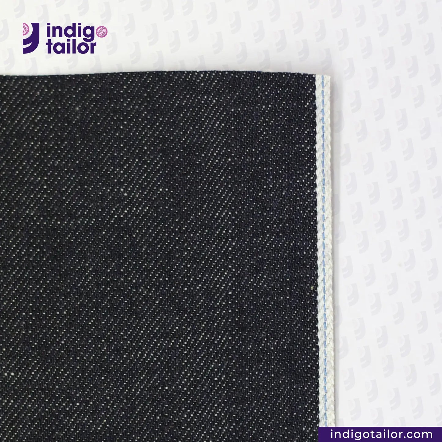 Close-up of TATE OCHI DOUBLE RING SPUN SELVEDGE DENIM fabric with 'Indigo Tailor' logo and website URL.