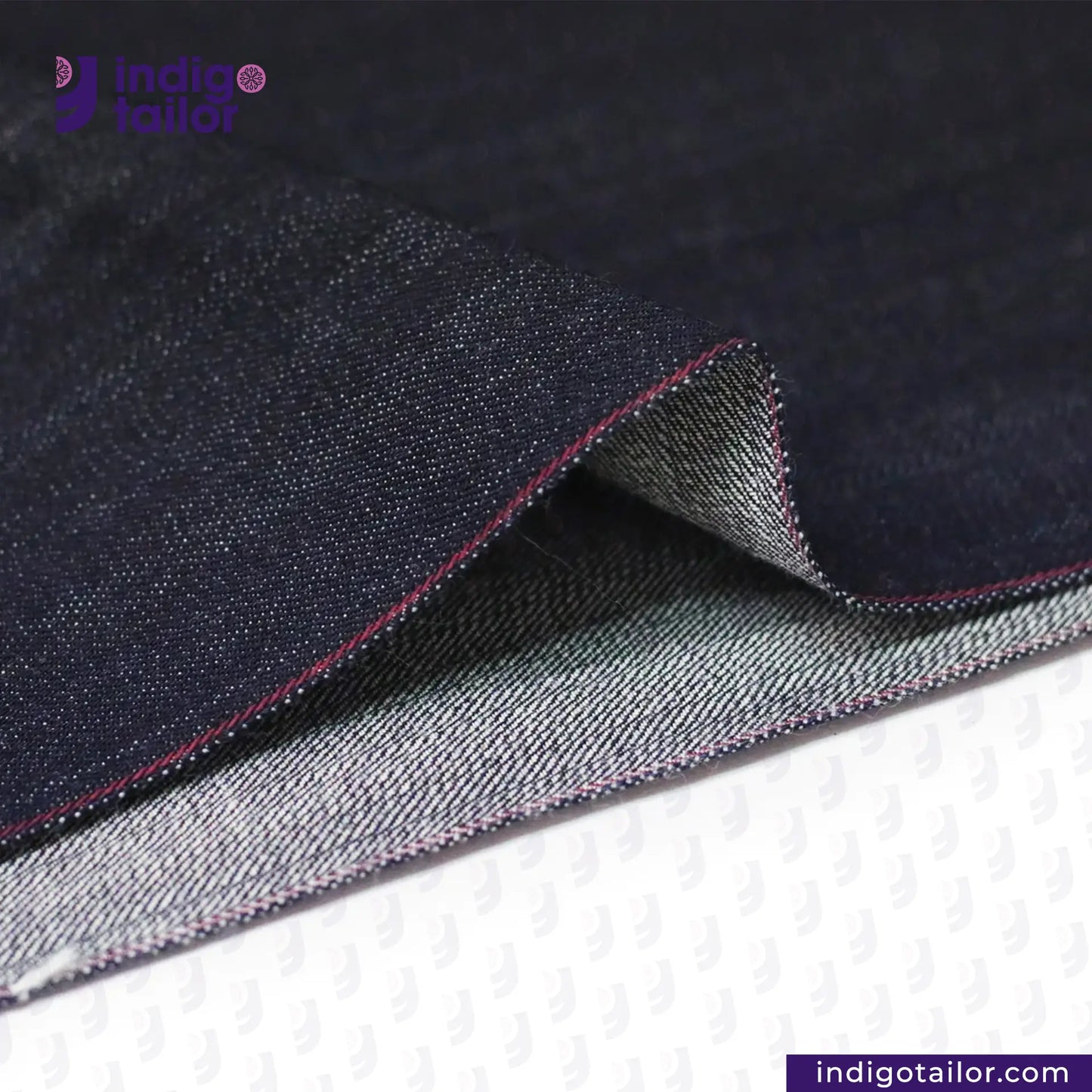 Close-up of TROPIC CITY DENIM fabric with visible stitching, featuring the Indigo Tailor logo.
