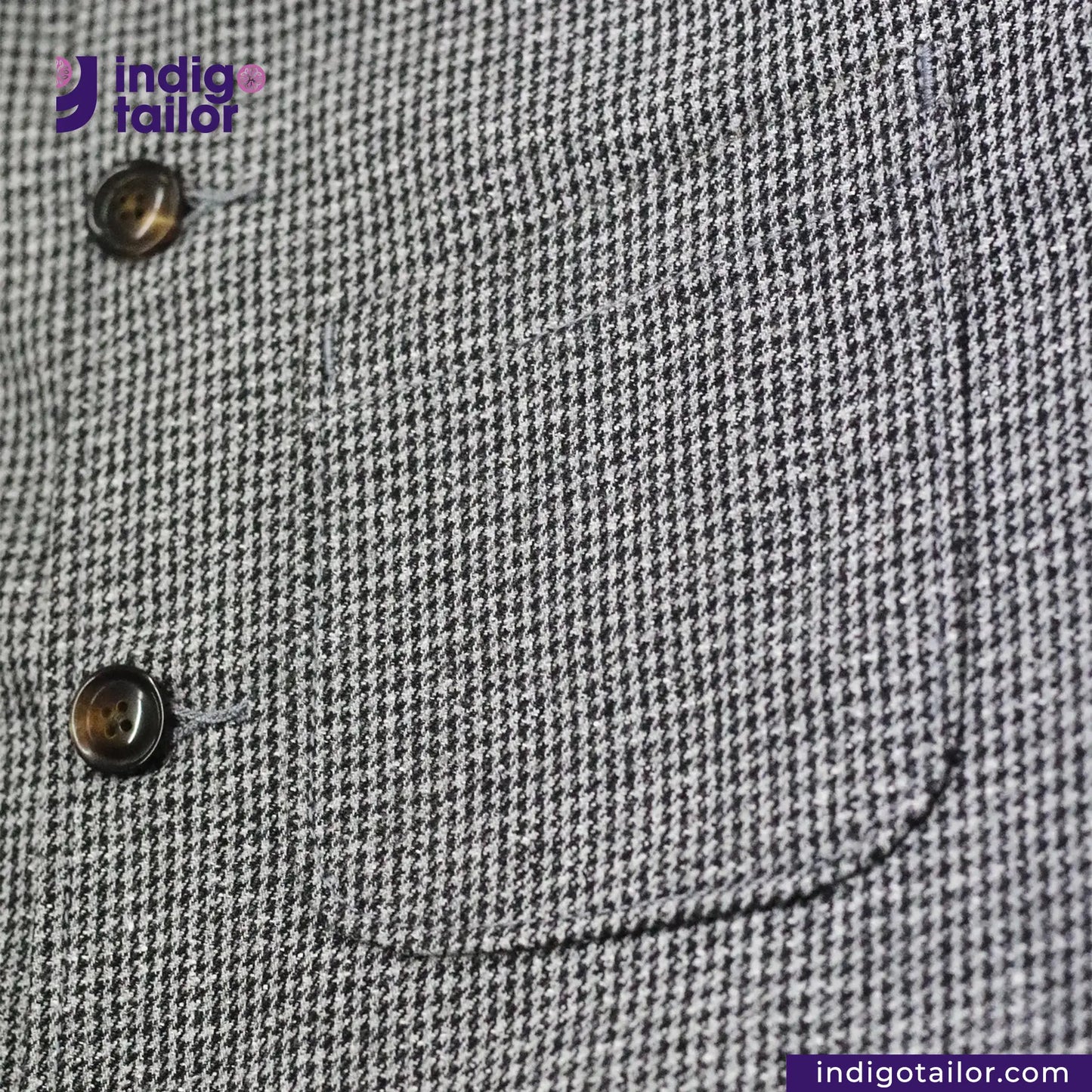 Close-up of a TWEED HOUNDSTOOTH COVERALL JACKET pocket with buttons, featuring the Indigotailor logo.