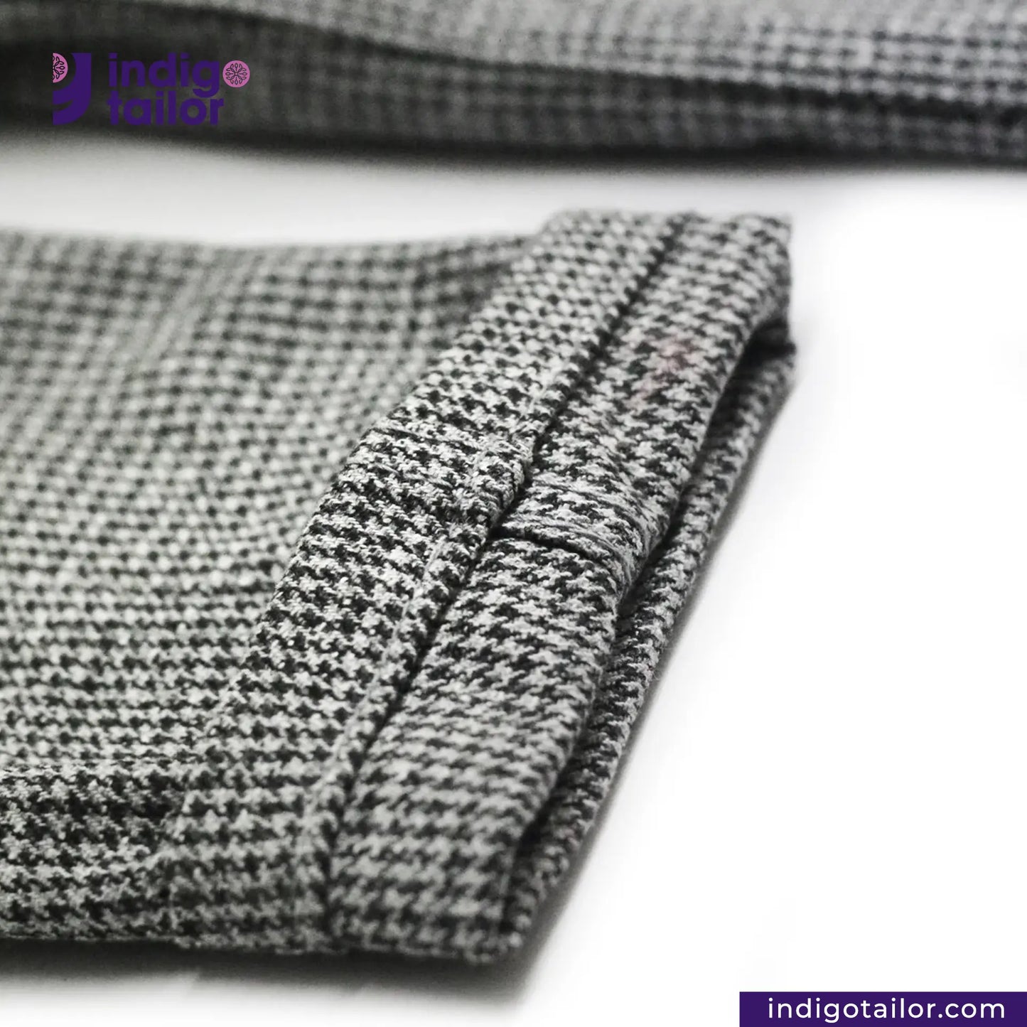 Close-up of TWEED HOUNDSTOOTH COVERALL JACKET pattern fabric with 'indigotailor' branding.