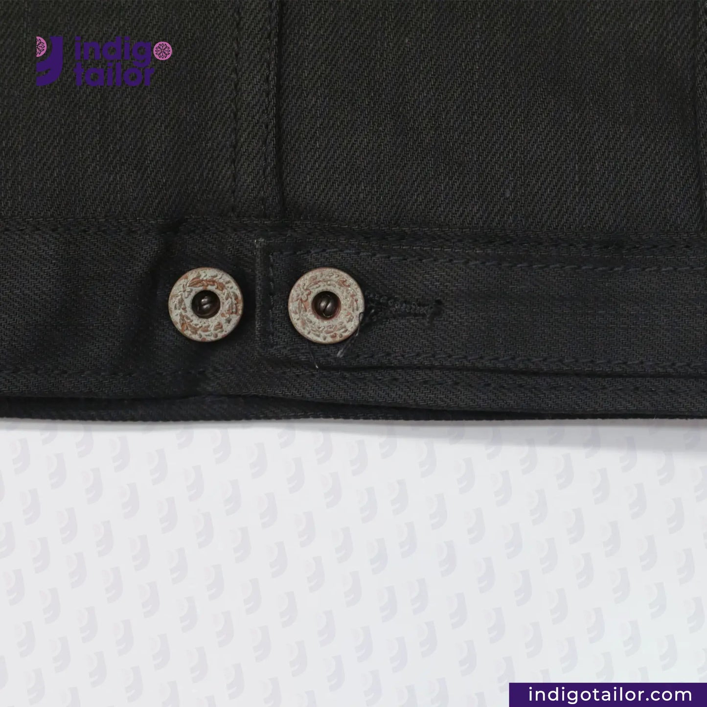 Close-up of TYPE III DOUBLE BLACK TRUCKER JACKET with buttons on a white background, featuring the Indigotailor.com logo.