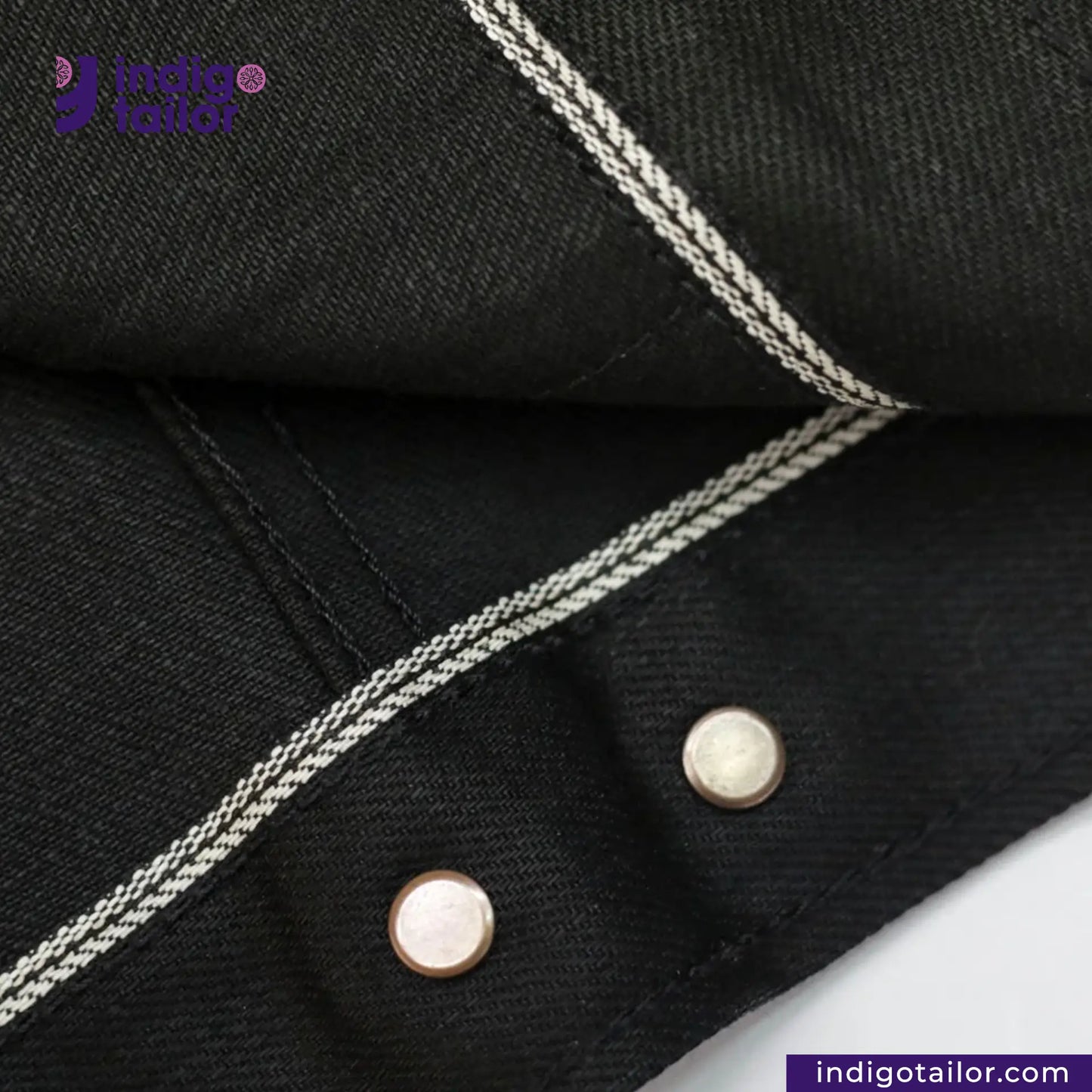 Close-up of TYPE III DOUBLE BLACK TRUCKER JACKET with white stitching and buttons, featuring Indigo Tailor logo.