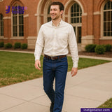 Man walking outdoors with a brick building in the background, wearing a white shirt and VINTAGE SKY BLUE DENIM jeans.