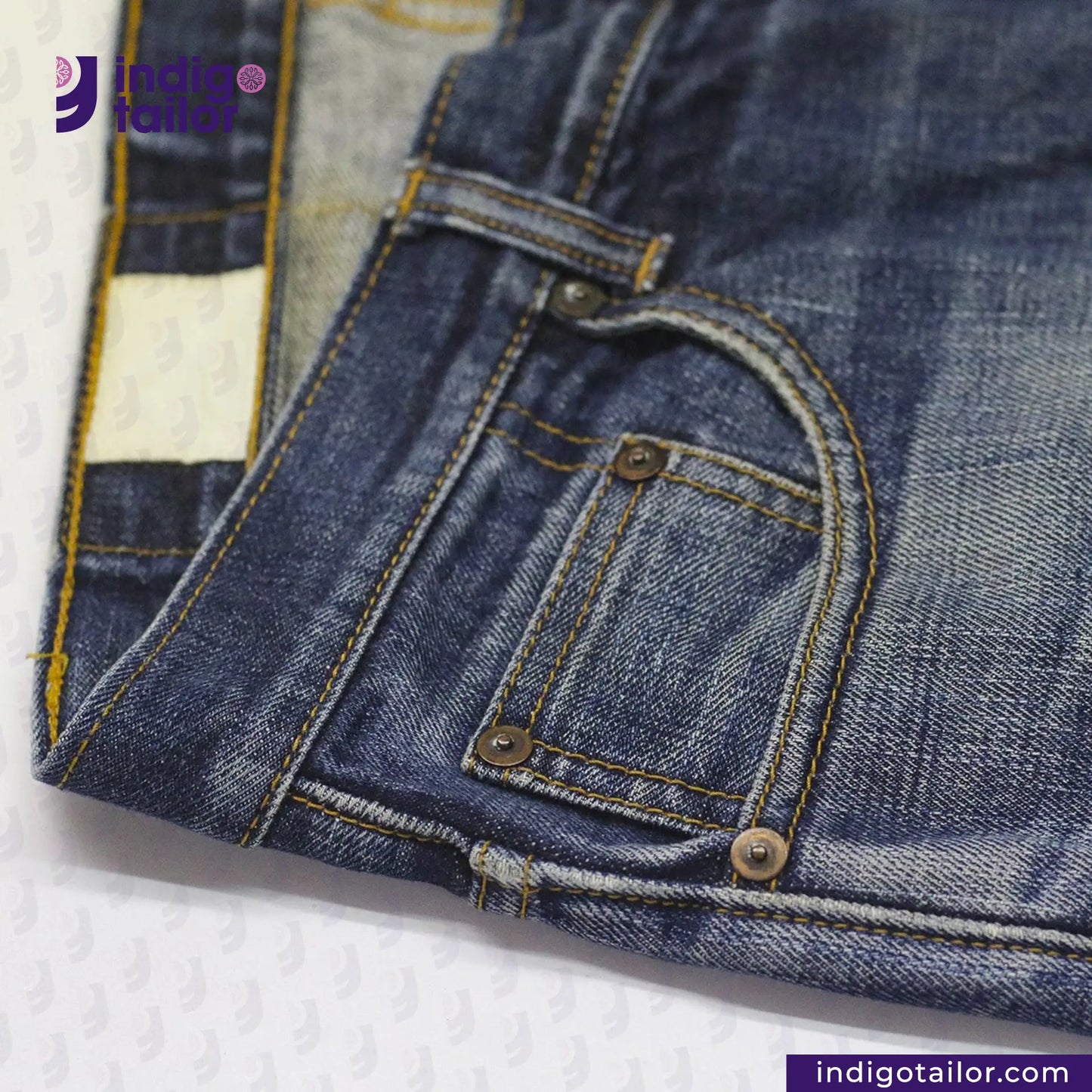 Close-up of VINTAGE SLUB DENIM jeans pocket area with a brand logo in the corner.