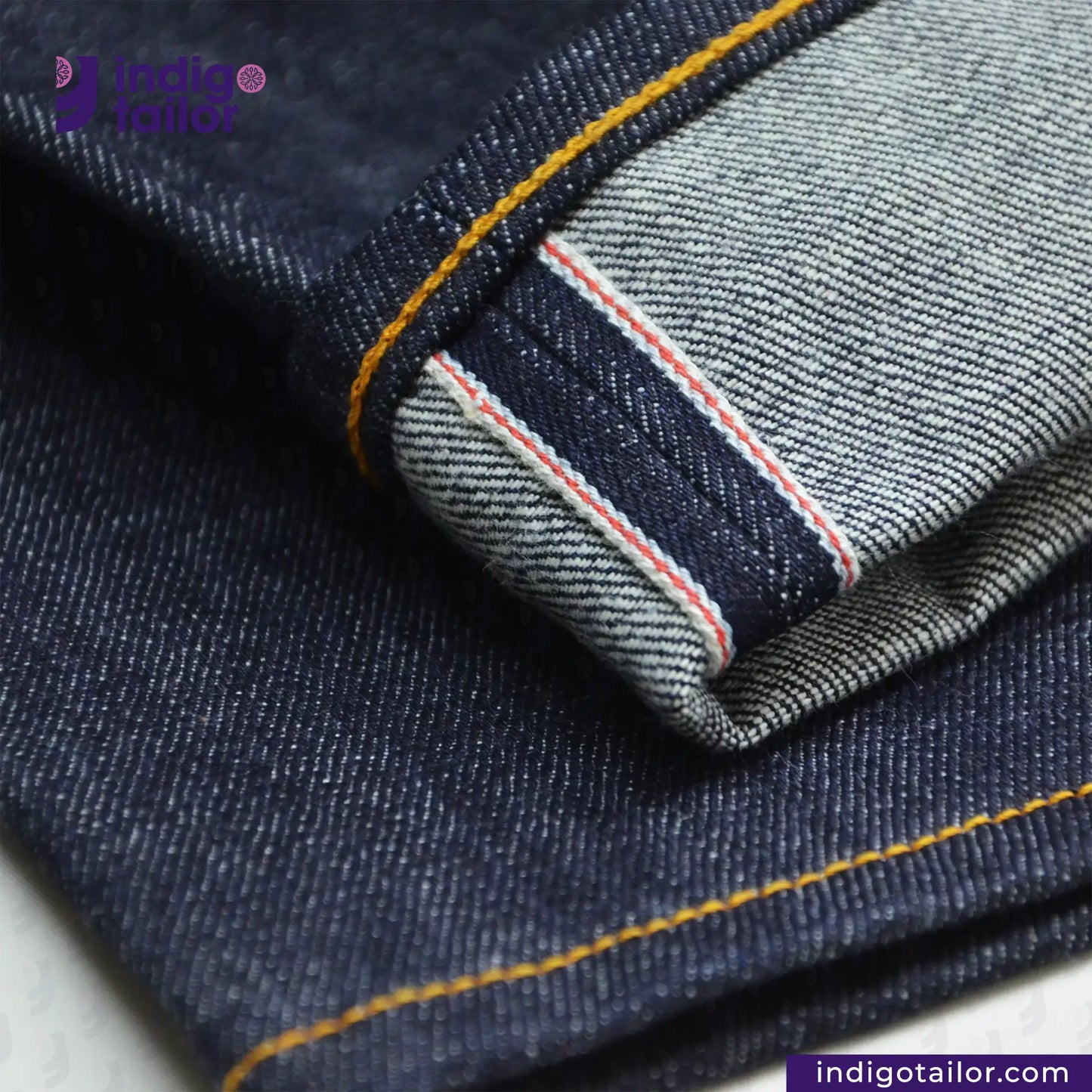 Close-up of VINTAGE SLUB DENIM jeans with a brand logo in the corner.