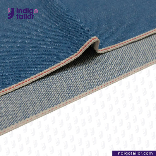 Close-up of AOZORA SKY BLUE SELVEDGE fabric with 'Indigotailor' branding on a white background
