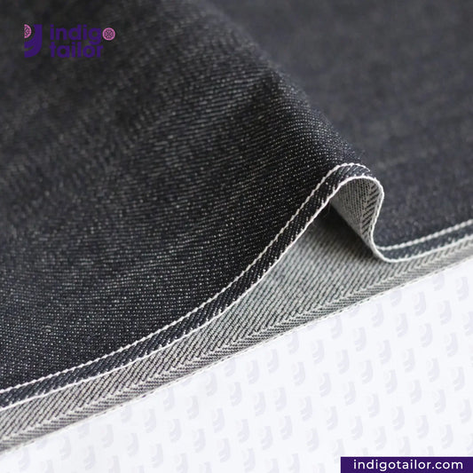 Close-up of CLASSIC BLUE SELVEDGE DENIM fabric with a visible brand logo on a white background