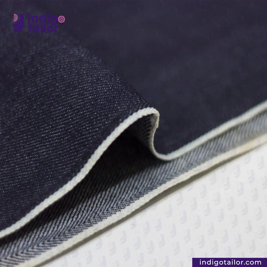 Close-up of COMFORT STRETCH WHITE SELVEDGE fabric with a visible brand logo on a white background