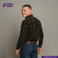Man wearing a CORD CAMO OVERSHIRT camouflage jacket and jeans with 'Indigo Tailor' logo and website on a gray background