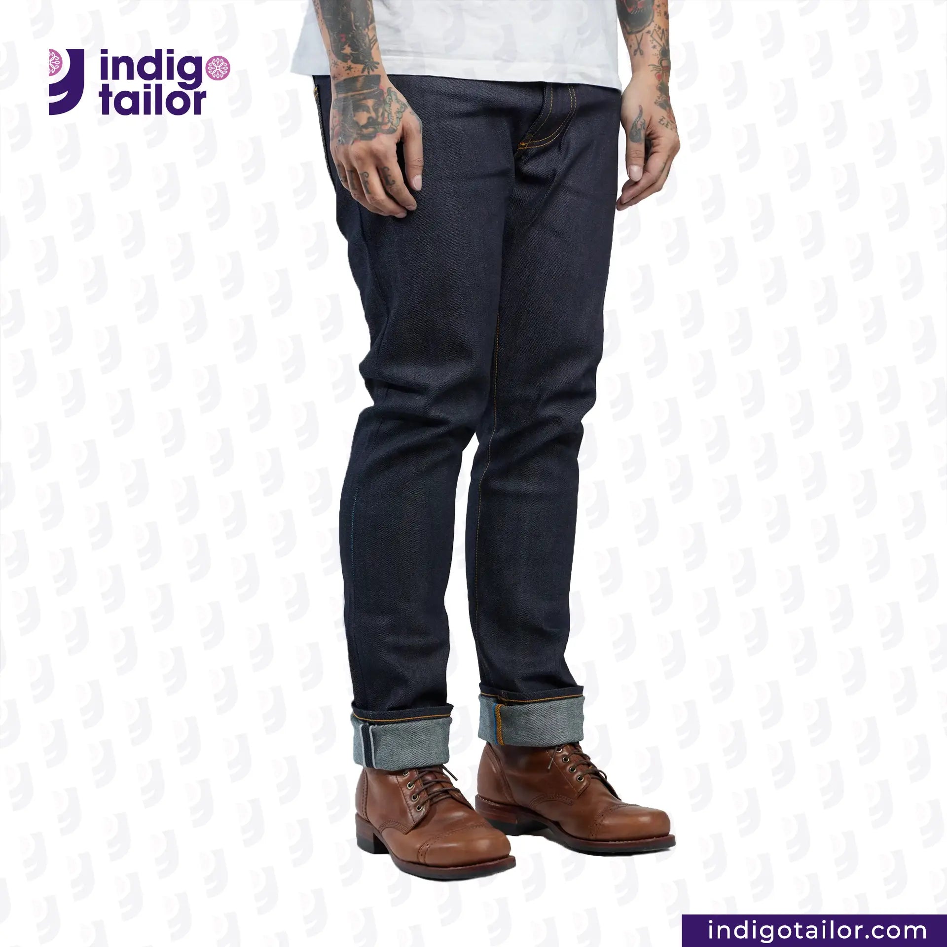 Person wearing Comfort Stretch Denim jeans with rolled-up cuffs and brown boots on a white background with 'Indigo Tailor' branding.
