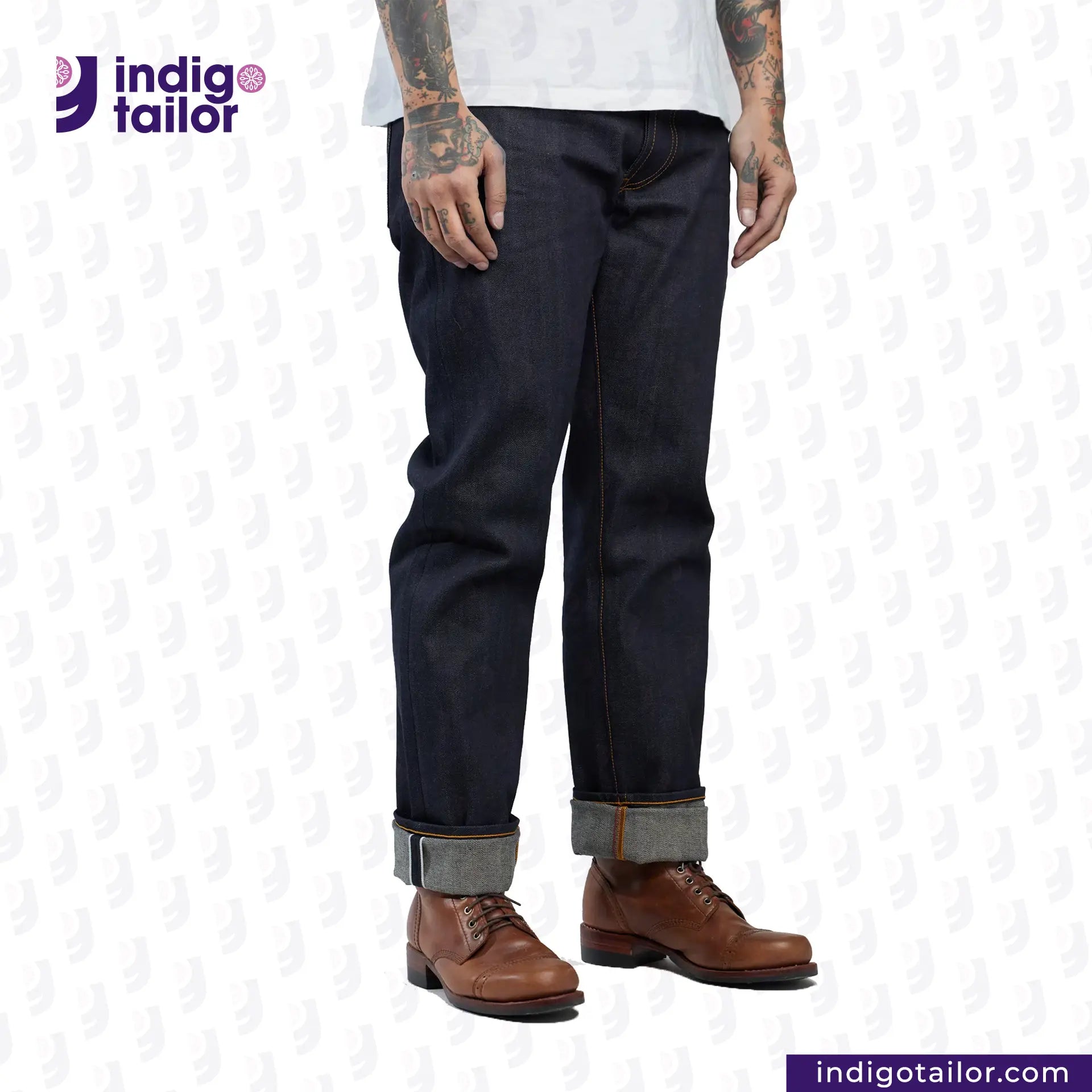 Person wearing DEEP BLUE OMBRÉ CAST DENIM jeans with rolled-up cuffs and brown shoes on a white background, with 'Indigo Tailor' branding.
