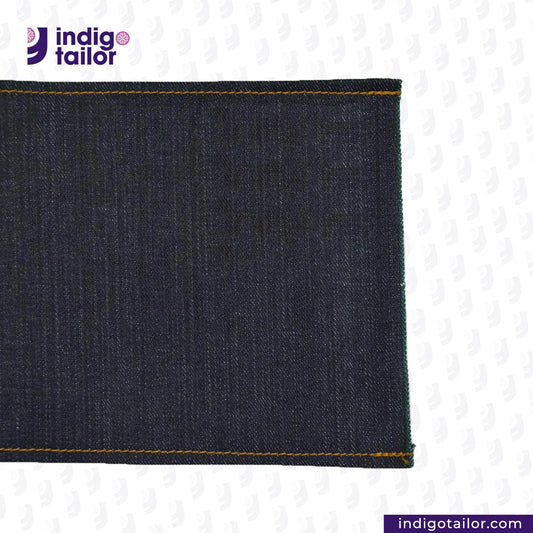 Close-up of DEEP INDIGO FOREST GREEN SELVEDGE DENIM fabric with 'Indigo Tailor' logo and website URL.